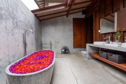 Stone bath with petals and rain shower