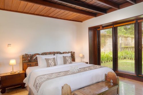 Main villa bedroom with carved teak headboard