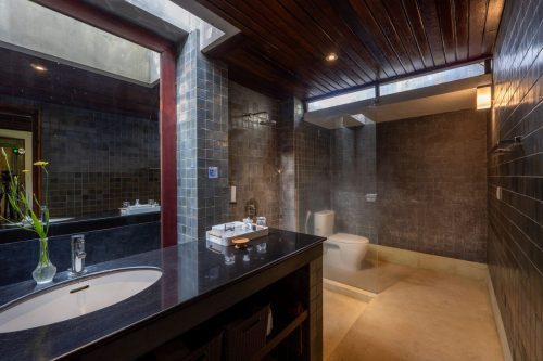 En-suite with sunken bath and stone walls